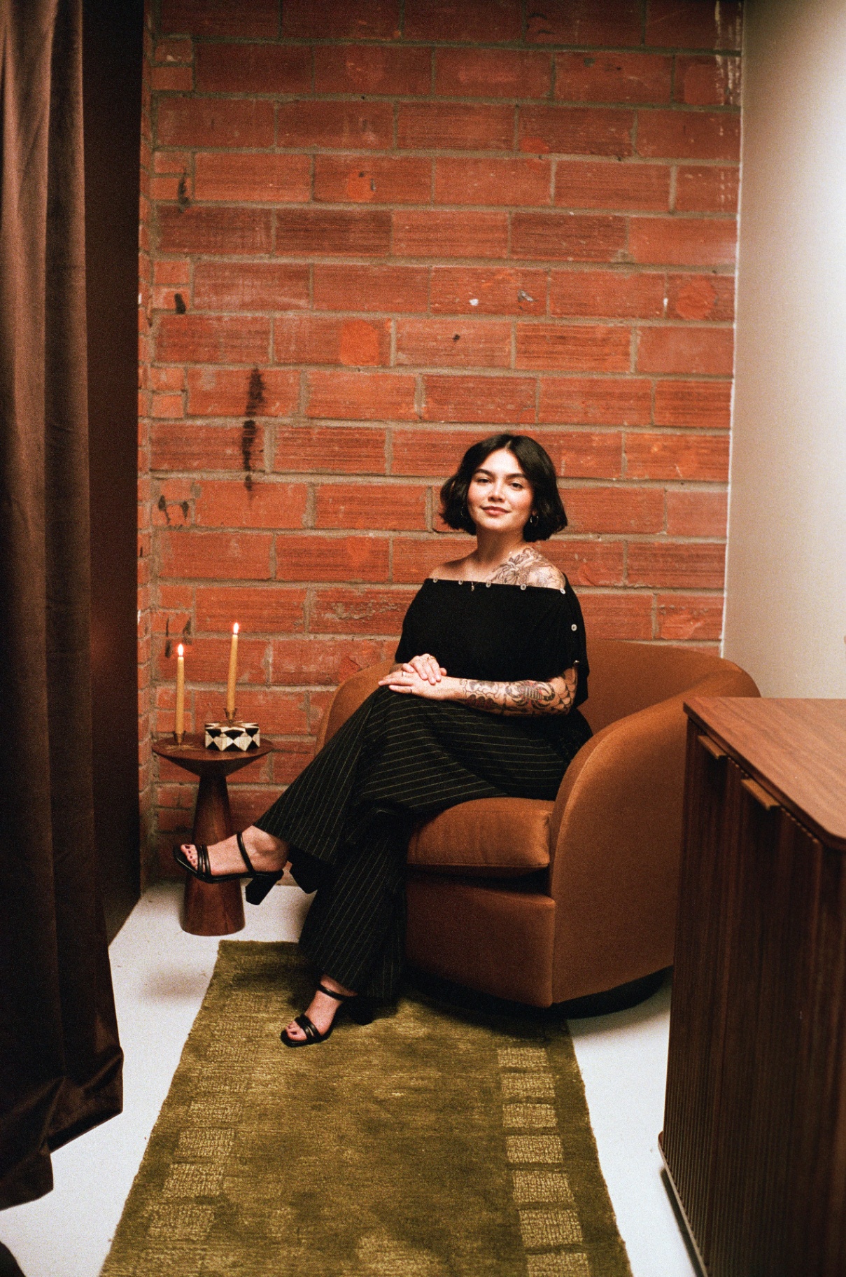 Portrait of the esthetician against an exposed brick wall