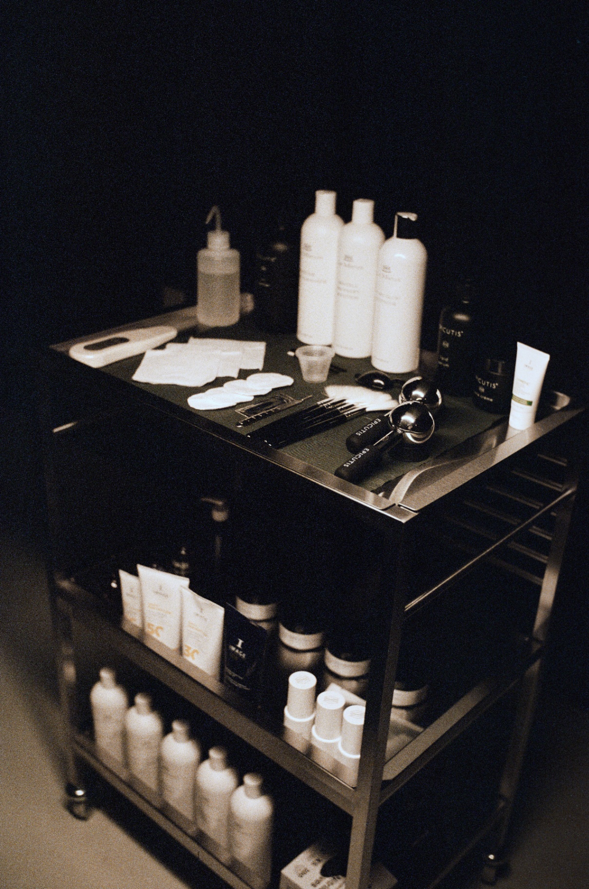 Studio trolley of professional skincare products under warm lamp light